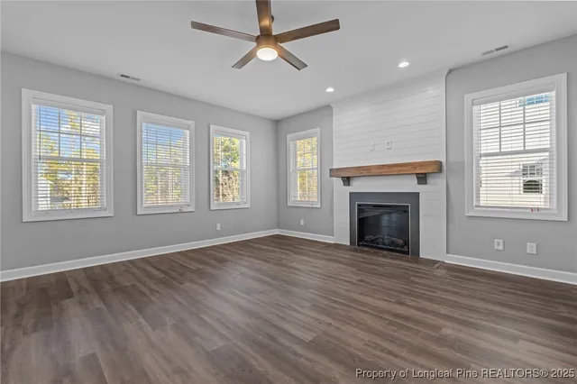 wooden floor fireplace and windows in an empty room