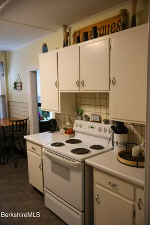 a kitchen with a sink a stove and white cabinets