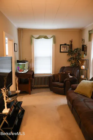 a living room with furniture a flat screen tv and a window