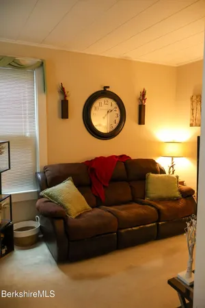 a living room with a couch and a lamp with potted plant