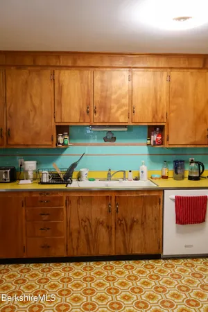 a kitchen with stainless steel appliances wooden cabinets and a large window