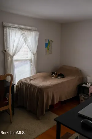 a bed sitting in a bedroom next to a window