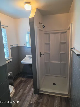 a bathroom with a shower a toilet and sink