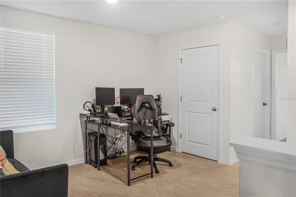 a view of a workspace with furniture and a window