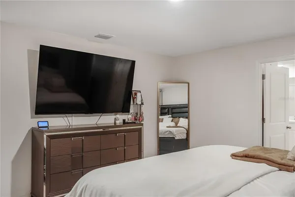 a bedroom with a bed and a flat screen tv