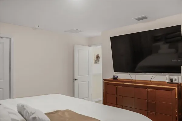 a bedroom with a bed and a flat screen tv