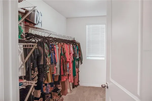 a view of walk in closet with clothes