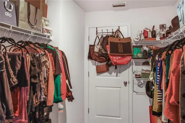 a view of walk in closet with clothes and shoes