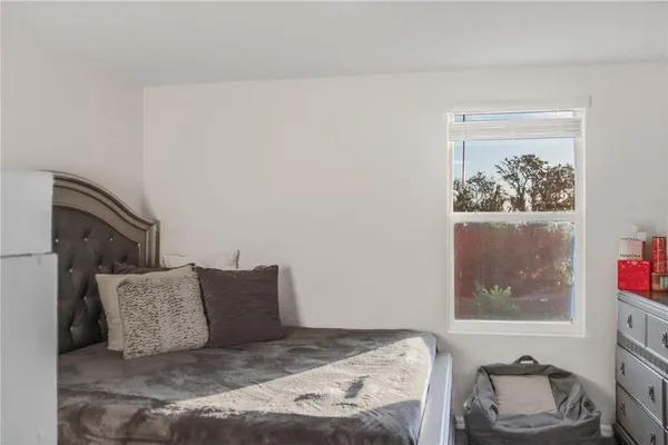 a large bed sitting in a bedroom next to a window