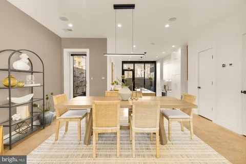 a view of a dining room with furniture a rug and wooden floor