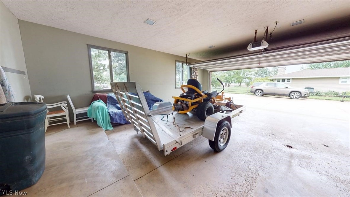 3985 Wiers Road Willard, OH 44890 - Photo 36 of 50 Attached garage with a roll-up door, concrete flooring, and ample natural light from exterior windows