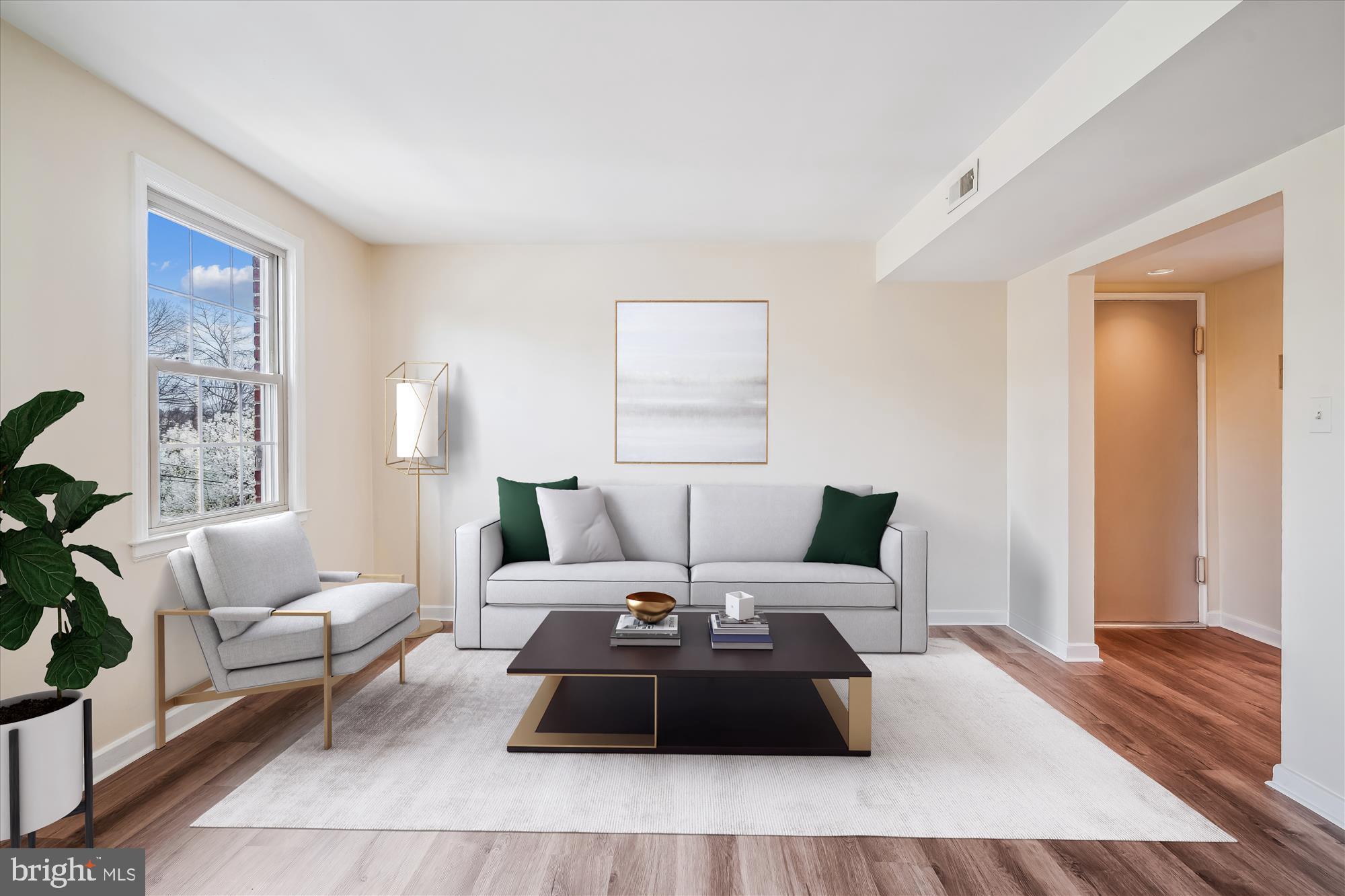 a living room with furniture and a wooden floor