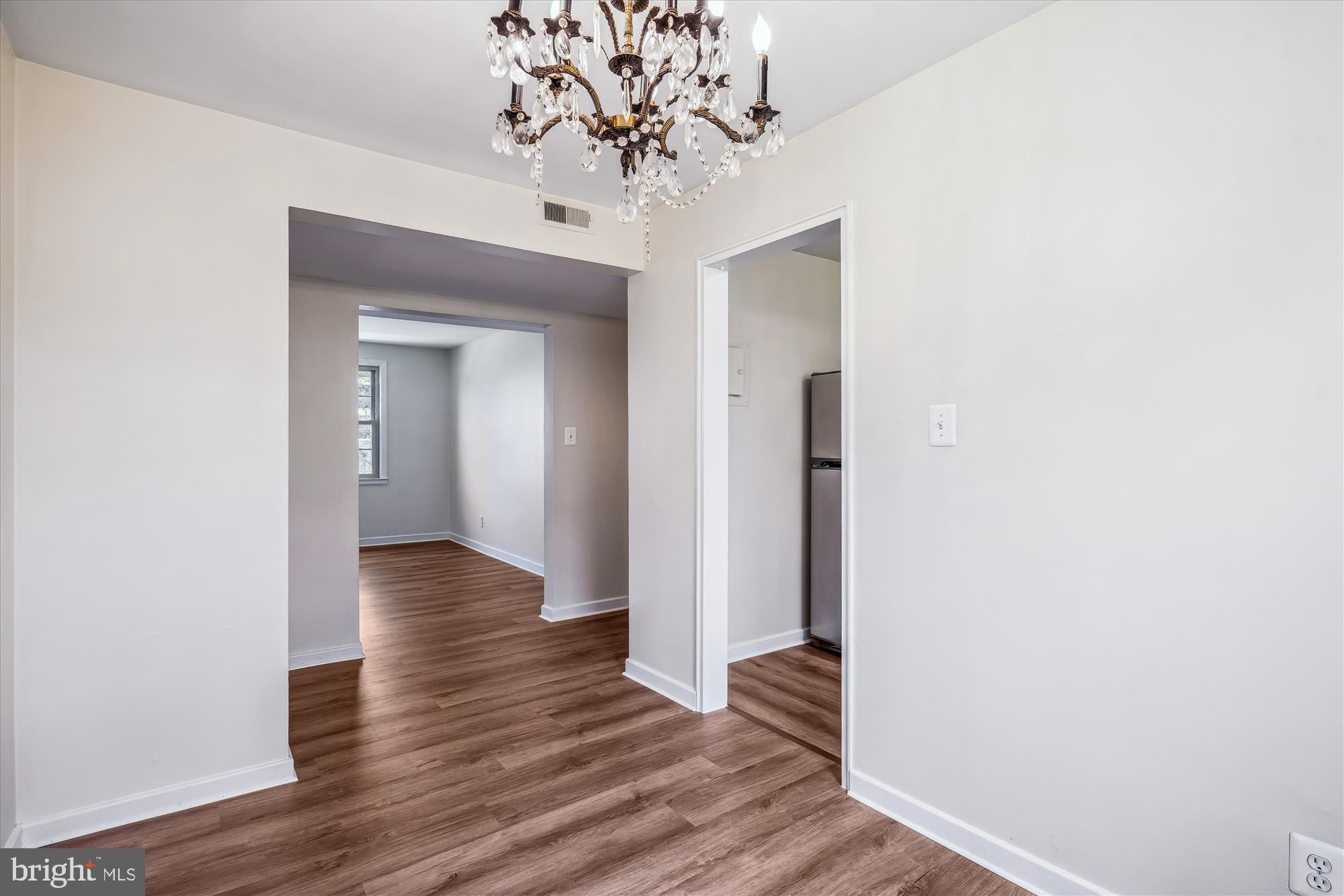 2202 Colston Drive, Unit 2202C Silver Spring, MD 20910 - Photo 10 of 42 a view of a hallway with wooden floor and a chandelier
