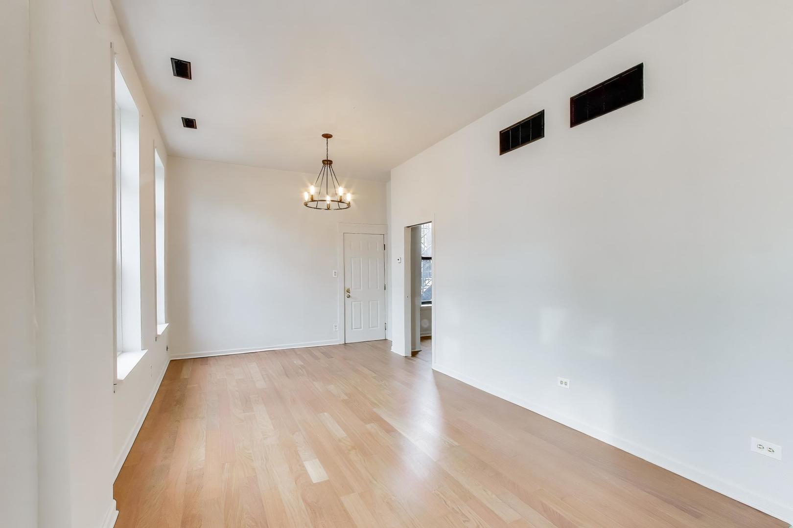 600 North May Street, Unit 2R Chicago, IL 60642 - Photo 7 of 19 wooden floor in an empty room with a window