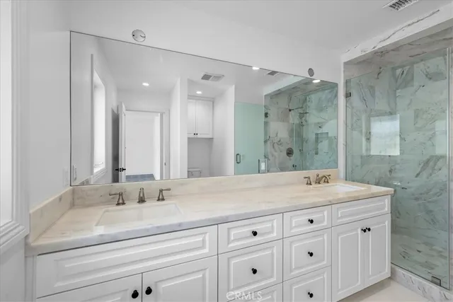 a bathroom with a sink shower and a mirror