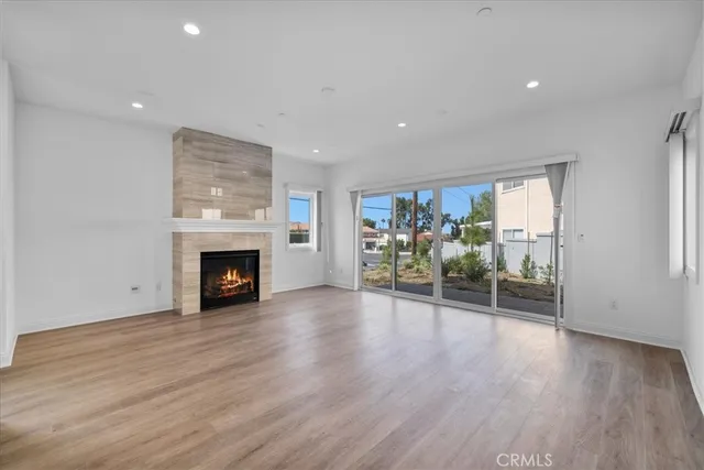 an empty room with wooden floor and fireplace