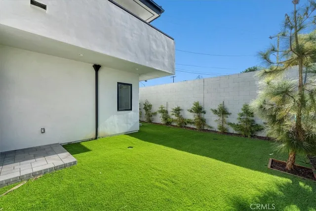 a view of a backyard with plants and a bench