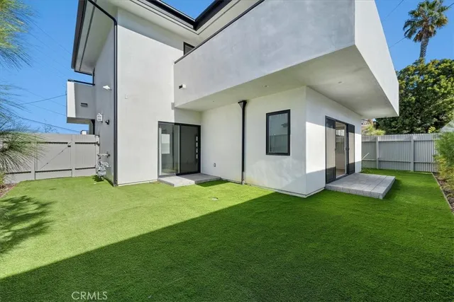 a view of a backyard with plants and large tree