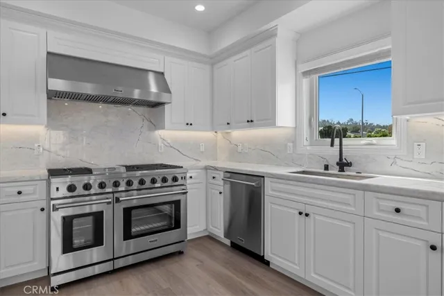 a kitchen with white cabinets and appliances