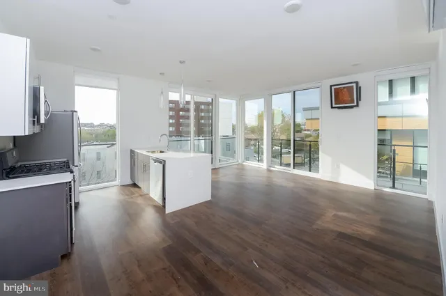 a view of a kitchen with wooden floor and a window