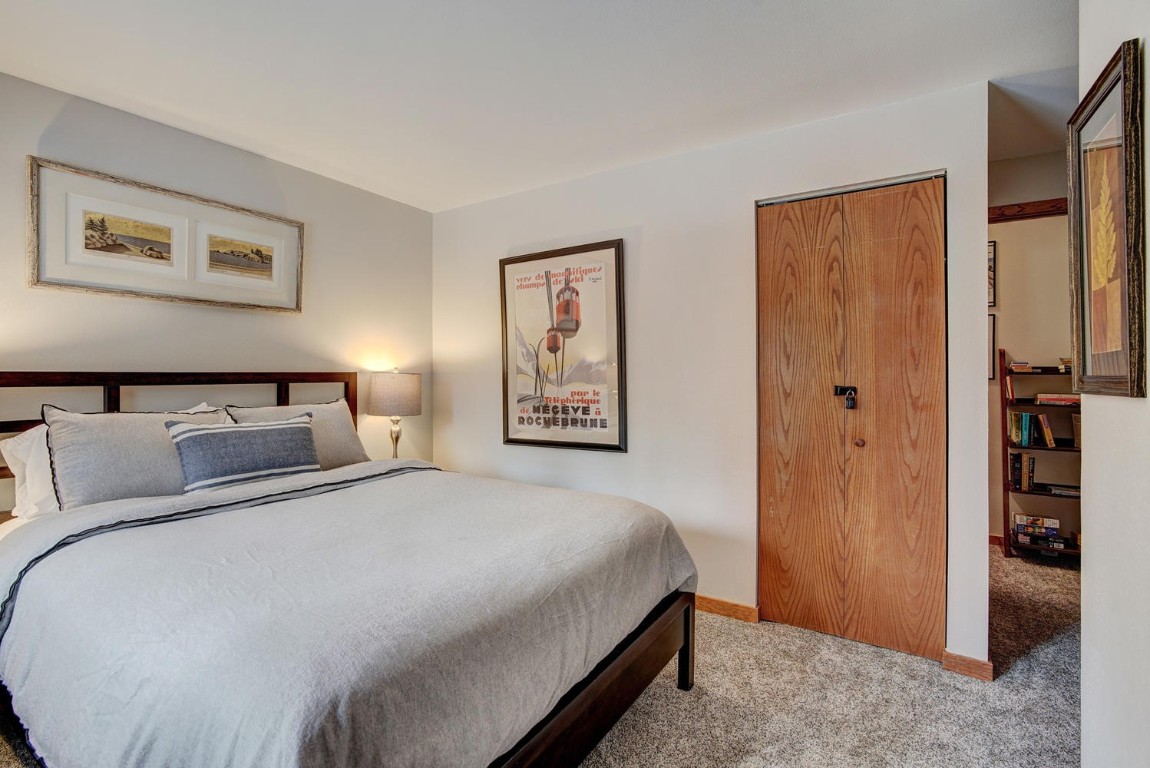 10000 Ryan Gulch Road, Unit 109 Silverthorne, CO 80498 - Photo 12 of 25 a bedroom with a large bed and a painting on the wall