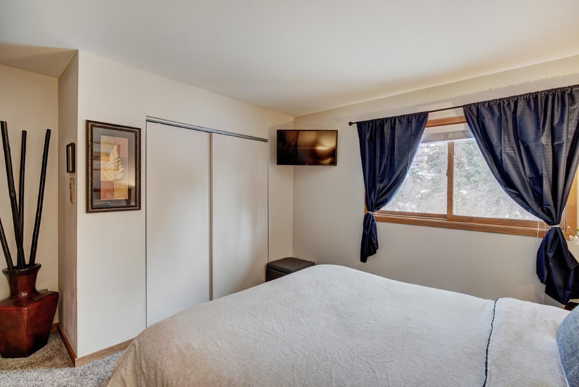 10000 Ryan Gulch Road, Unit 109 Silverthorne, CO 80498 - Photo 13 of 25 a bedroom with a bed and a television