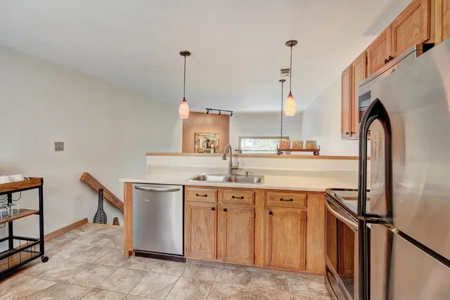 a kitchen with stainless steel appliances a sink a counter top space and cabinets