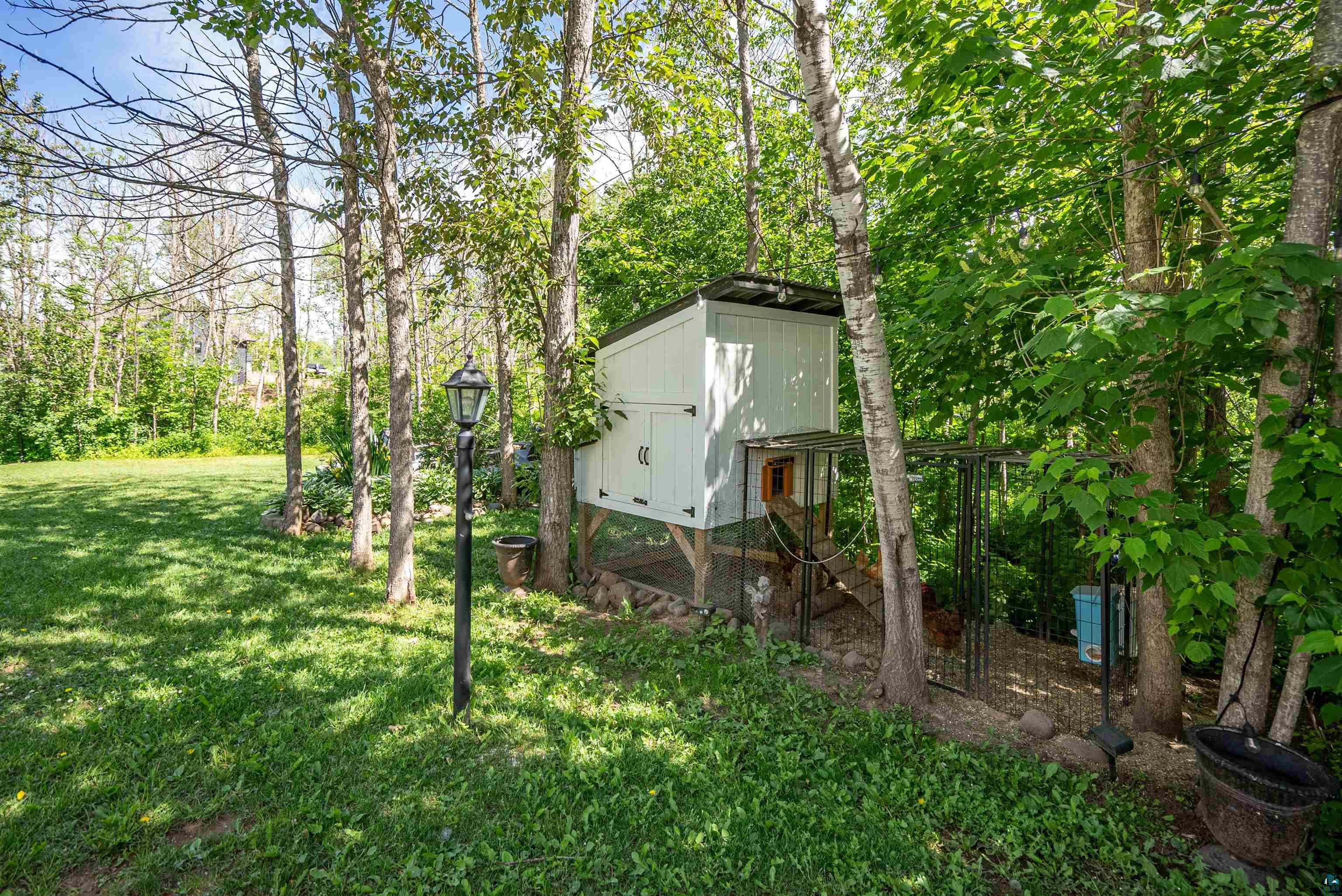 4809 Oak Ridge Drive Hermantown, MN 55811 - Photo 60 of 67 White-sided outbuilding with black trim and enclosed run, surrounded by mature trees