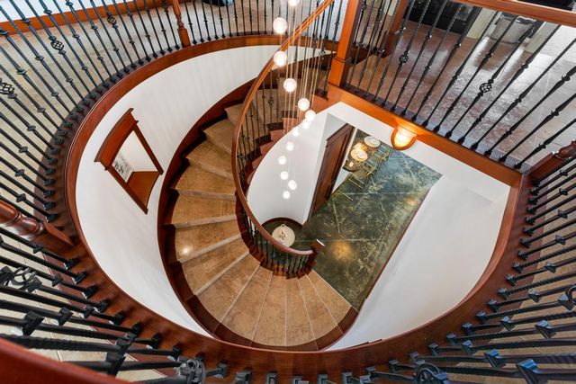 a view of staircase with railing and a rug