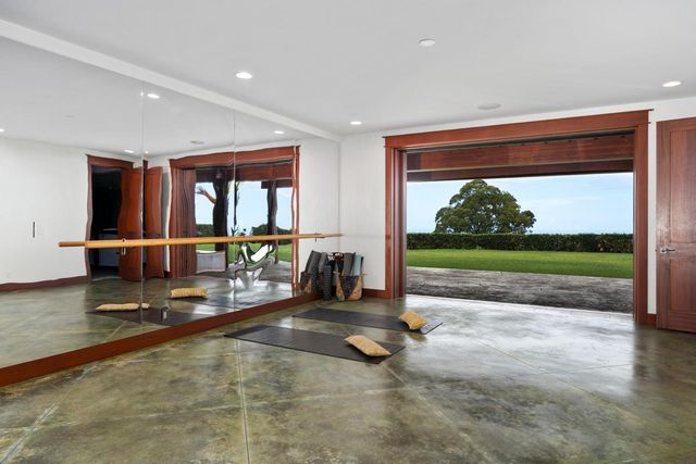 a room with gym equipment and large windows