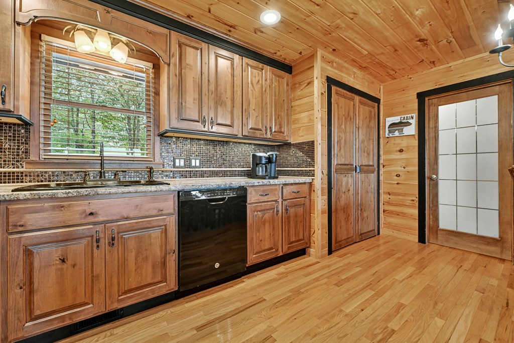 296 Overlook Road Blue Ridge, GA 30513 - Photo 41 of 65 a kitchen with stainless steel appliances granite countertop a refrigerator a sink dishwasher and wooden cabinets with wooden floor