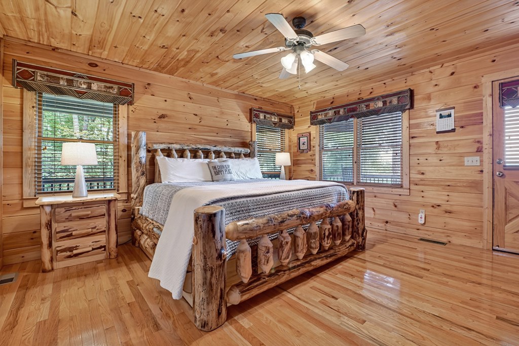 296 Overlook Road Blue Ridge, GA 30513 - Photo 44 of 65 a bedroom with a large bed a chandelier and windows