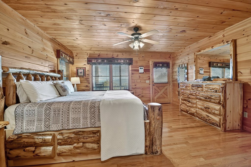 296 Overlook Road Blue Ridge, GA 30513 - Photo 45 of 65 a spacious bedroom with a bed a dresser and a chandelier