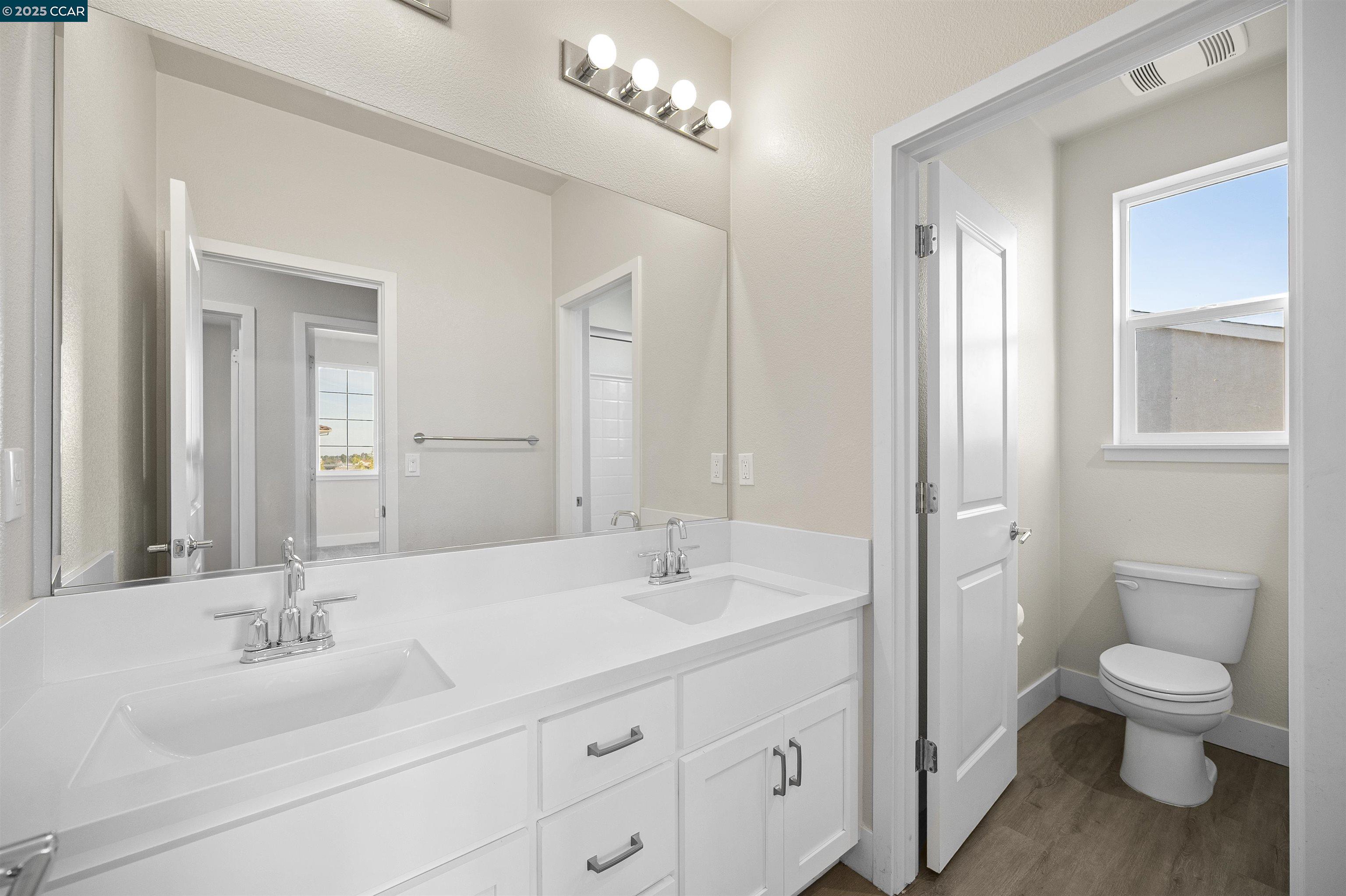 5541 Promontory Way Antioch, CA 94531 - Photo 15 of 59 a bathroom with a toilet a sink a mirror and a shower