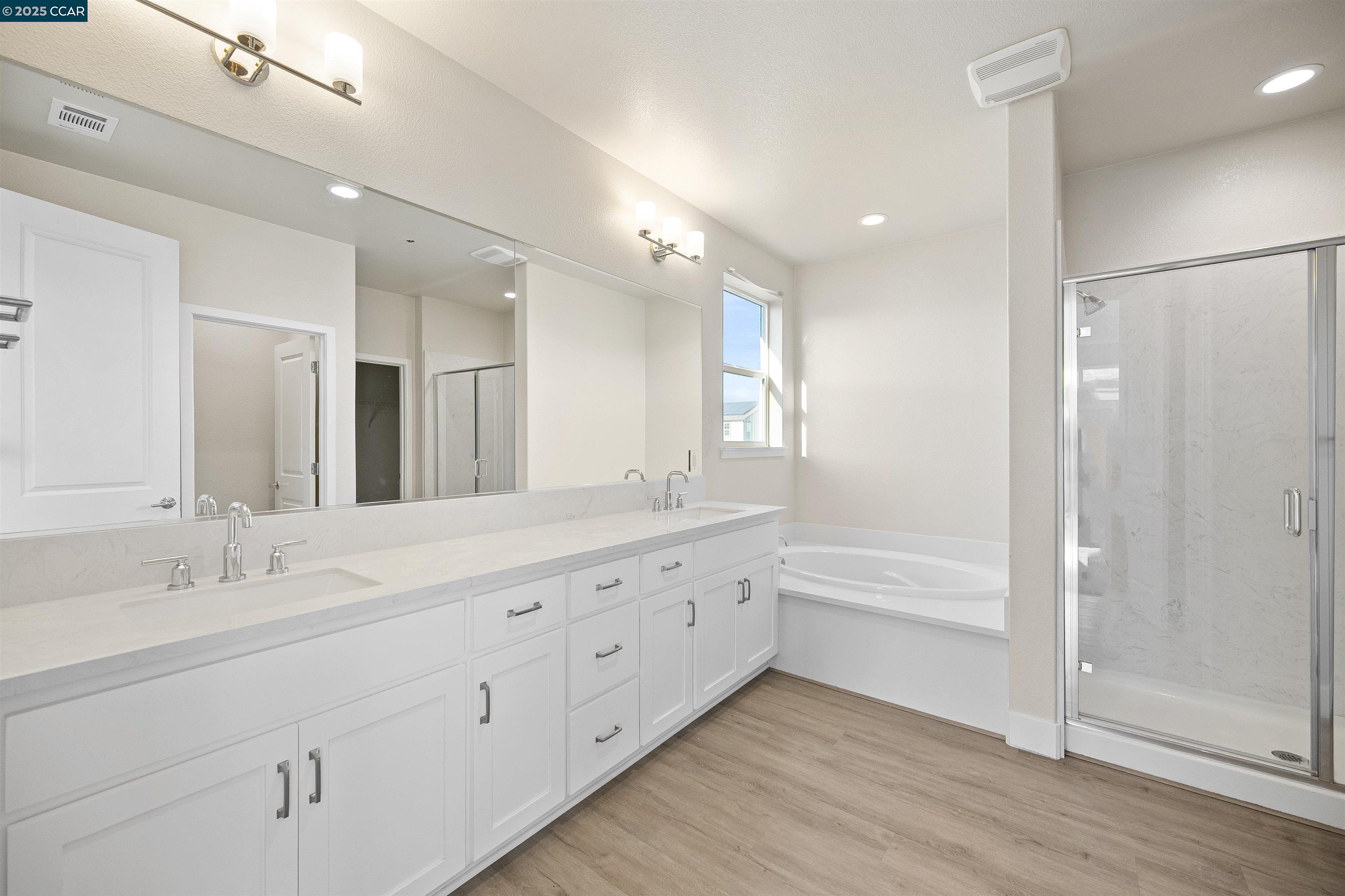 5541 Promontory Way Antioch, CA 94531 - Photo 28 of 59 a bathroom with a double vanity sink a mirror and a bathtub