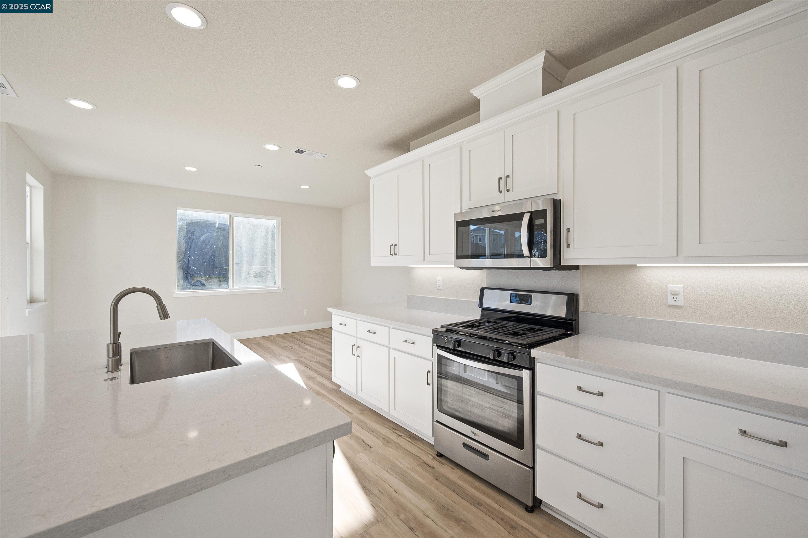 5541 Promontory Way Antioch, CA 94531 - Photo 43 of 59 a kitchen with granite countertop white cabinets and stainless steel appliances