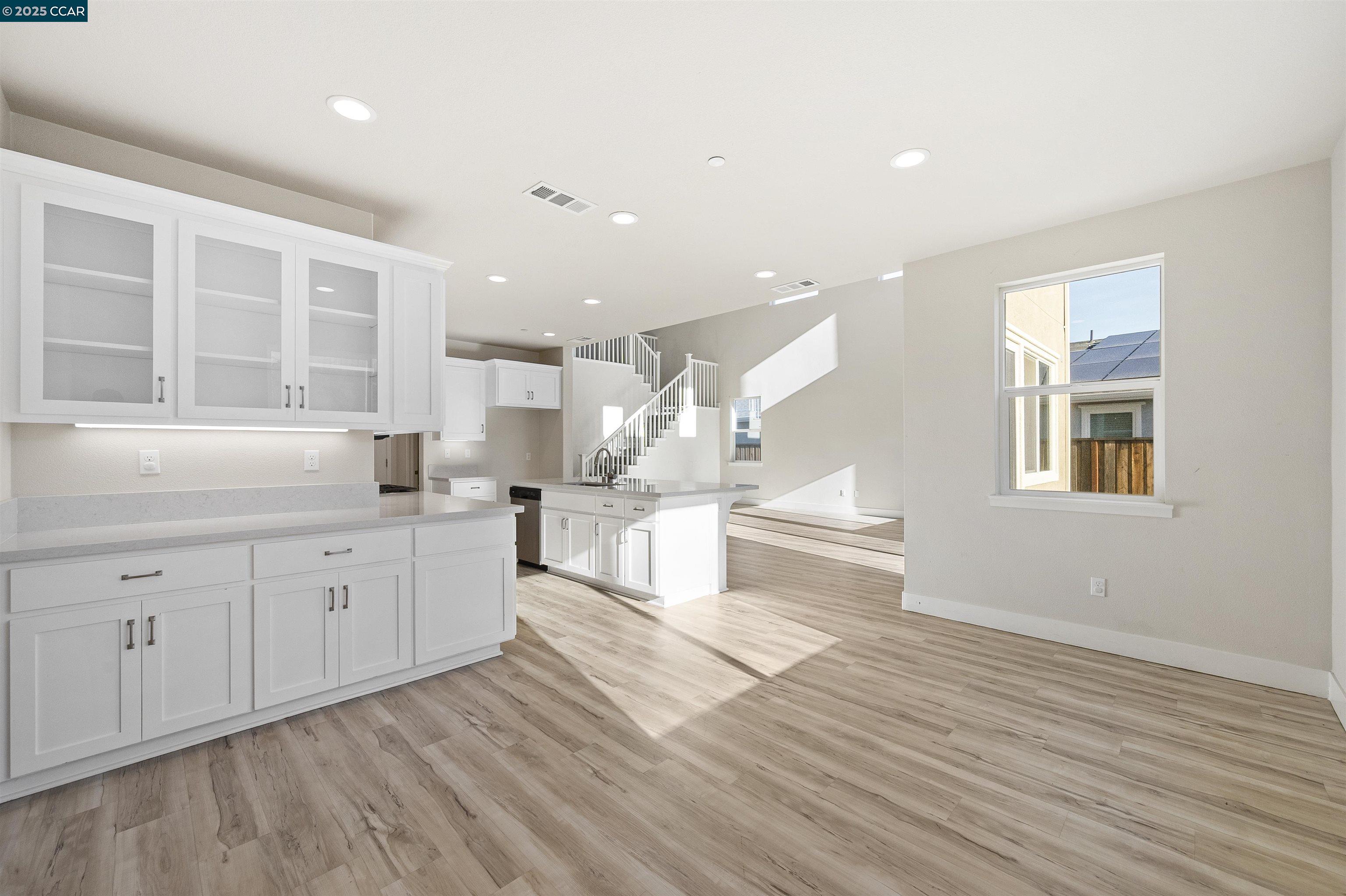 5541 Promontory Way Antioch, CA 94531 - Photo 47 of 59 a open kitchen with white cabinets and wooden floor