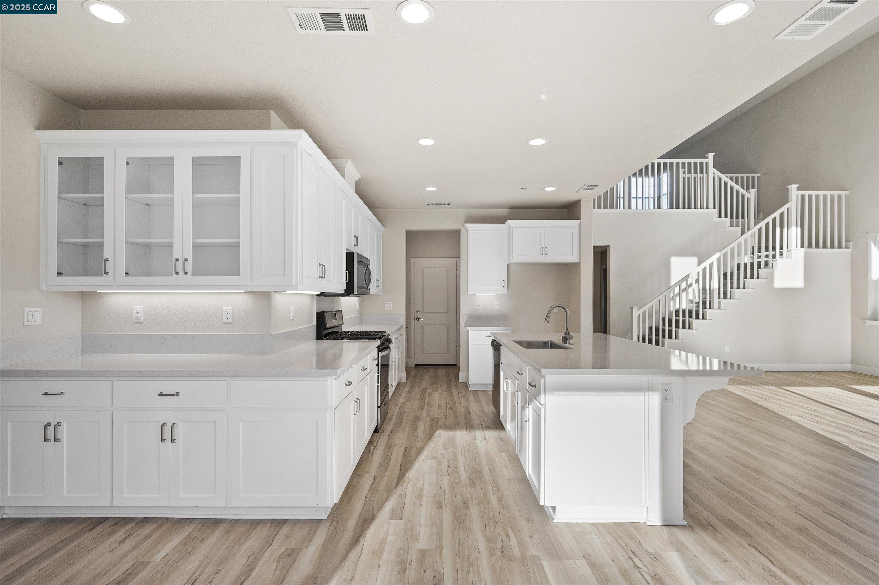 5541 Promontory Way Antioch, CA 94531 - Photo 48 of 59 a large white kitchen with cabinets a sink and a stove