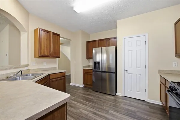 a kitchen with a refrigerator sink and wooden floor