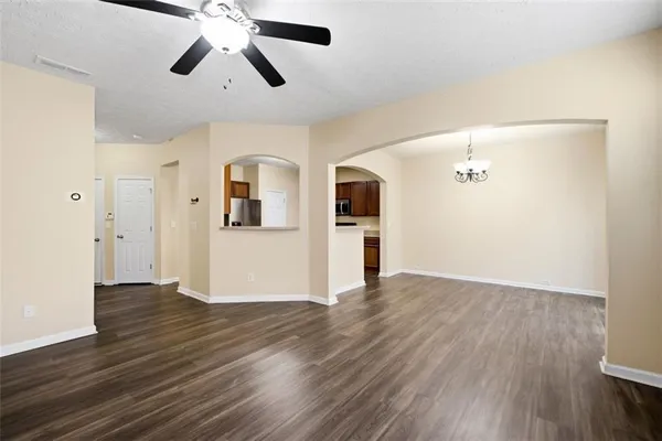 a view of empty room with wooden floor and ceiling fan