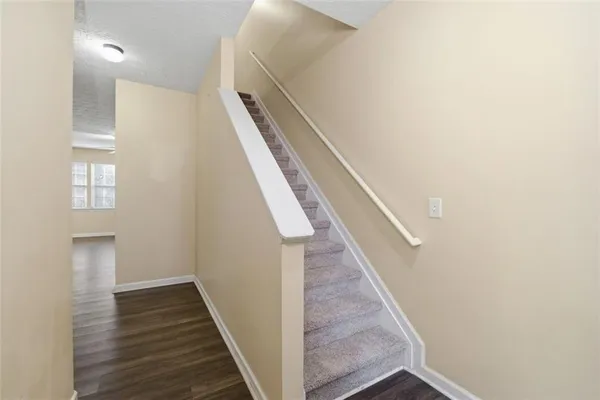 a view of a hallway with wooden floor and staircase