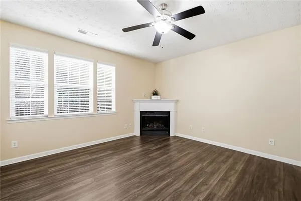 wooden floor fireplace and windows in an empty room