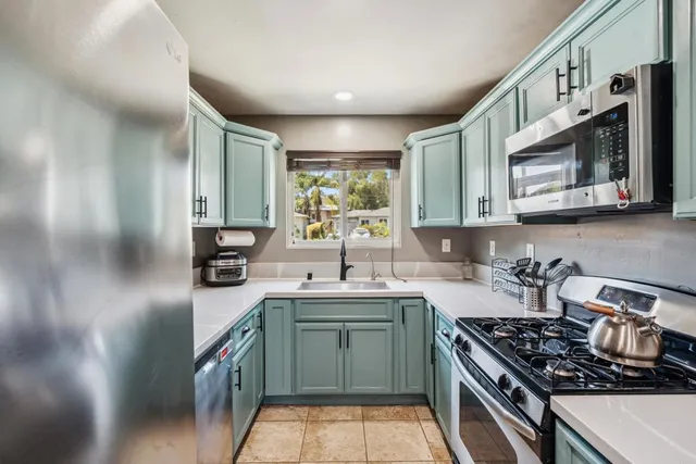 a kitchen with stainless steel appliances a sink stove and cabinets