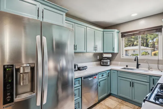 a kitchen with stainless steel appliances granite countertop a refrigerator a sink a stove and washer