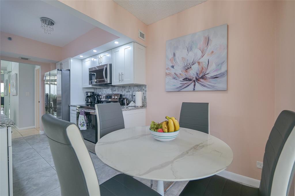 7300 Radice Court, Unit 404 Lauderhill, FL 33319 - Photo 16 of 85 a view of a dining room with furniture and wooden floor