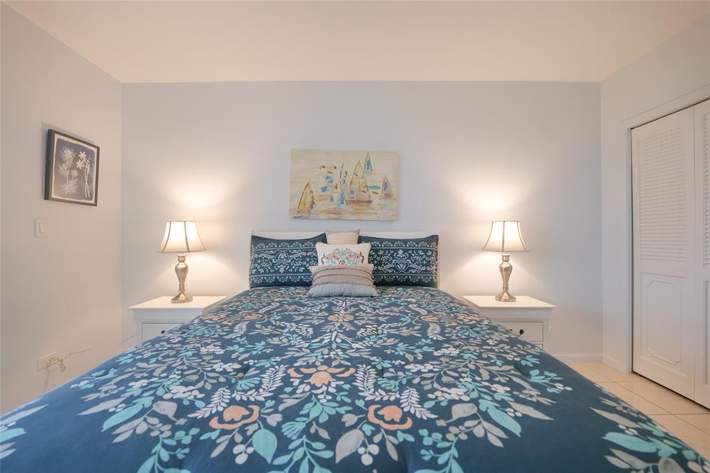 7300 Radice Court, Unit 404 Lauderhill, FL 33319 - Photo 30 of 85 a large bed sitting in a bedroom next to a lamp