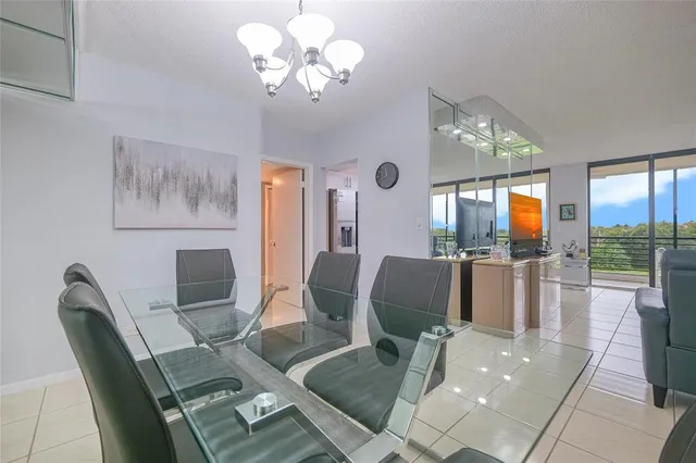 a kitchen with granite countertop a refrigerator and chairs
