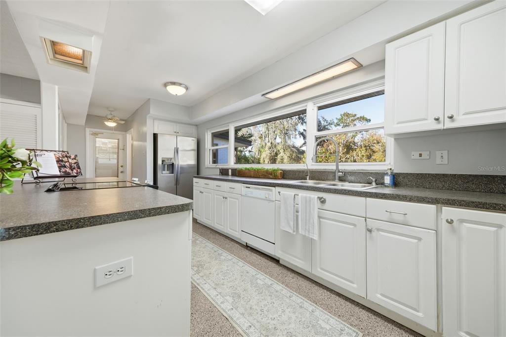 9214 Rhea Drive Odessa, FL 33556 - Photo 19 of 67 a kitchen with granite countertop white cabinets and a sink