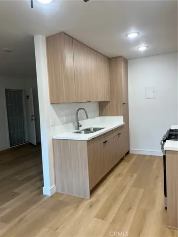 a kitchen with a sink cabinets and wooden floor