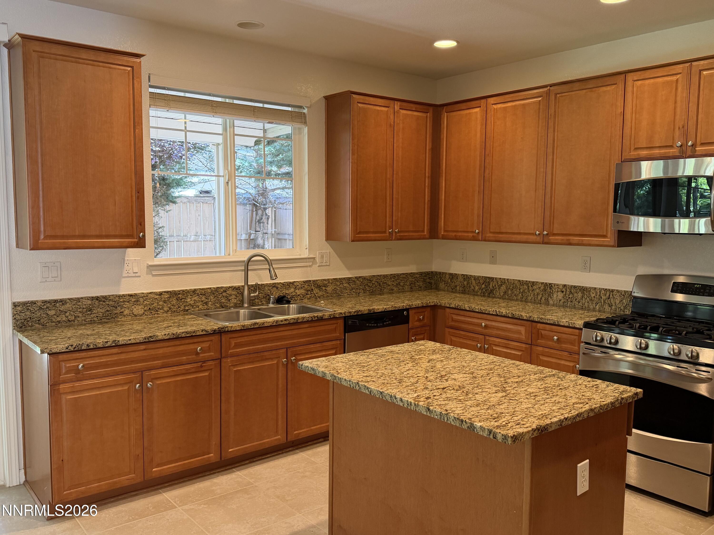 10890 Oakhaven Drive Reno, NV 89521 - Photo 28 of 28 a kitchen with granite countertop sink stove and cabinets